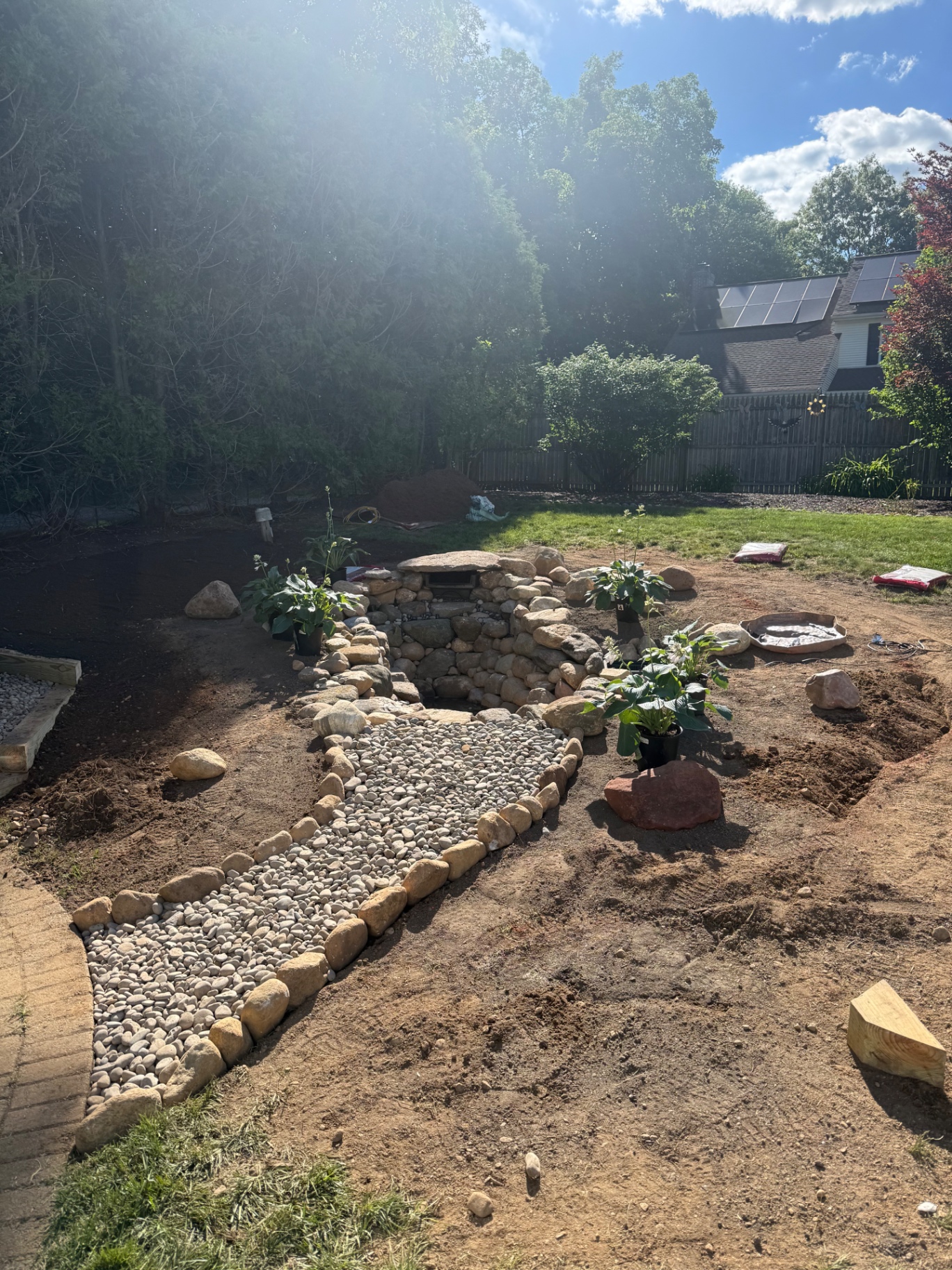 Stone waterfall and river-rock dry bed taking shape during construction in Naugatuck, CT