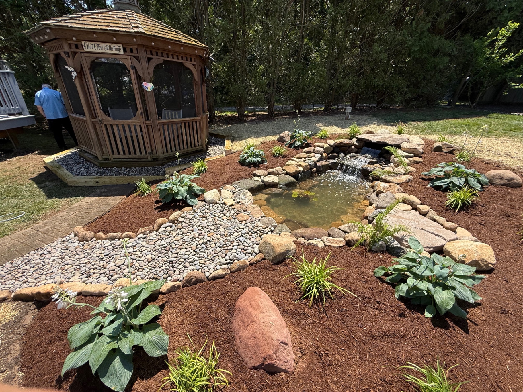 Naturalistic pond paired with a wooden gazebo sitting area in Naugatuck, CT